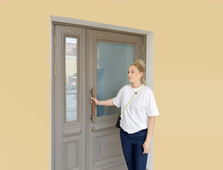 Woman opening doors of house (hotel, store)