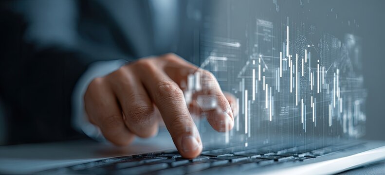 Close-up of hands interacting with holographic financial charts displayed on a laptop keyboard