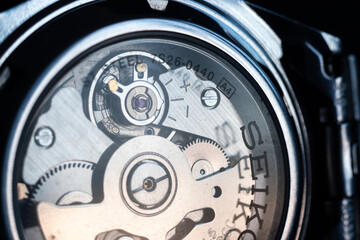 Gears and pendulum in wrist watch close up, transparent glass back of Seiko watch