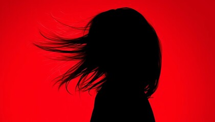 Silhouette of head tossing long hair against vibrant red backdrop, studio, fierce
