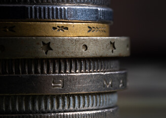 Pile of various coins close up, coin edges are reeded and decorated with shapes and letters, uncirculated metal money with corrosion and secretases