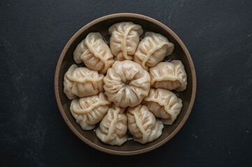 Raw dumplings served in a disposable container on a dark stone surface