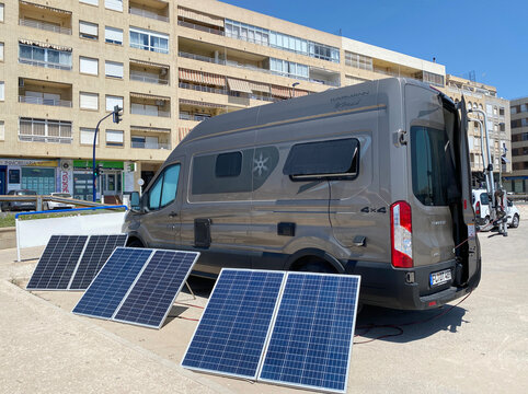 Torrevieja, Spain - May 30, 2025:Portable solar panels charging battery near camper van