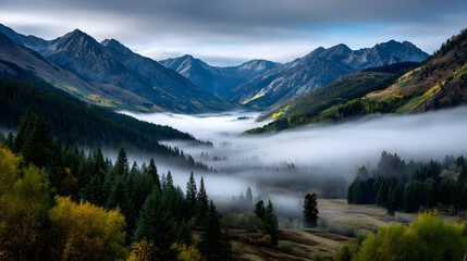 A serene valley blanketed in mist beneath radiant auumn mountain colors.