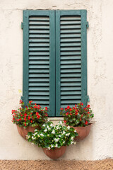 Finestra con persiane e vasai di fiori