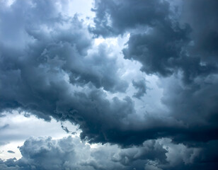 Obraz premium Dramatic dark storm clouds fill the sky, hinting at an approaching tempest. Perfect for weather, atmospheric, or background visuals.