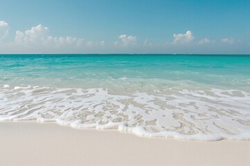 Fototapeta premium Ocean wave rolling onto pale beach sand