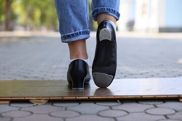 Teenage girl in tap shoes dancing outdoors, closeup