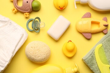 Baby bath accessories on yellow background, flat lay