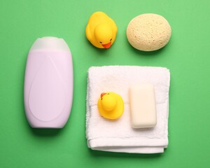 Baby bath accessories on green background, flat lay