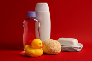 Baby bath accessories and care products on red background