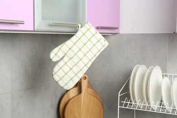 Oven glove hanging on handle of cabinet in kitchen
