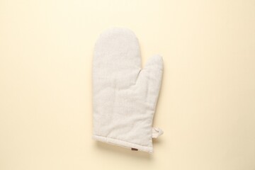 One oven glove on beige background, top view