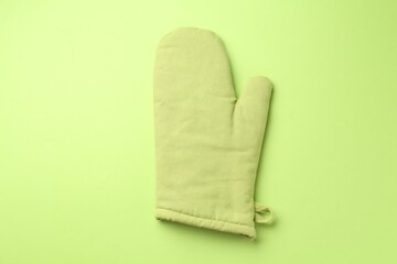 One oven glove on green background, top view