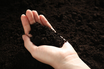Woman with pile of fresh soil, closeup
