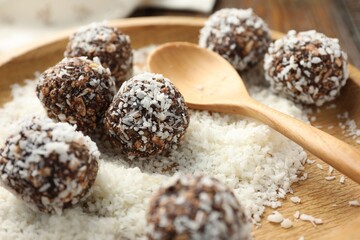 Tasty chocolate candies with nuts and coconut flakes on table, closeup