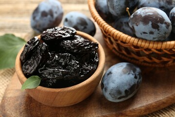 Dried prunes and fresh plums on table, closeup