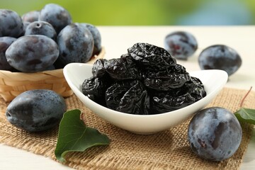 Dried prunes and fresh plums on table, closeup