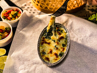 Baked spinach with melted cheese served in an oval gratin dish, golden and creamy