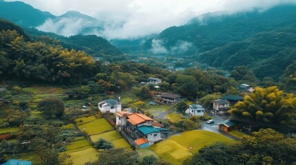 Picturesque aerial view of a rural village nestled within lush, verdant mountains