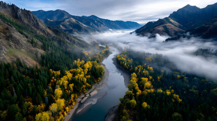An aerial view of a river winding through autumn moutain valleys, with golden rees lining the riverbanksand mist rising from the vlley floor.