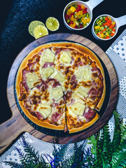 Hawaiian pizza topped with pineapple, bacon, and melted cheese, delicious and savory.