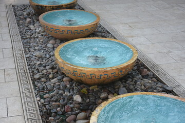 Naklejka premium Small decorative fountains on rocks with yellow and blue details
