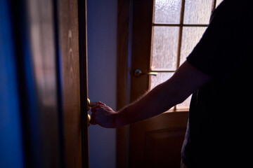 A hand is positioned on the door knob, fully prepared to open the entrance with ease