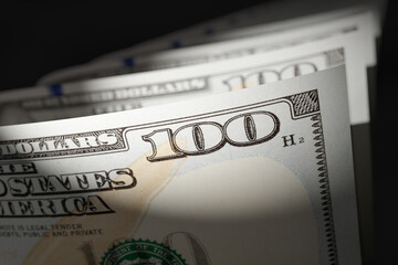 Spot Lit Abstract CLose-up Angle of U.S. 100 Dollar Bills Isolated on a Black Background.