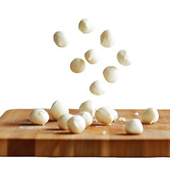 Fresh mozzarella balls falling onto wooden cutting board isolated on transparent background