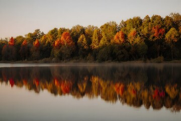 A lake with a reflection of autumn trees, smooth water, bright colors of foliage, warm evening sun