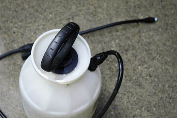 looking down at a multi-purpose pump sprayer on wet concrete. abstract background. driveway...