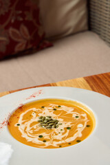 Indulge in a delightful bowl of creamy pumpkin soup, attractively and beautifully garnished