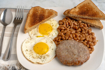 fried eggs  with sausage patty  anf baked beans