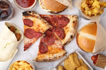 Different delicious fast food and soda drink on white marble table, flat lay