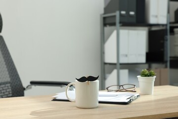 Happy Father's Day. Cup with paper moustache and clipboard on wooden table