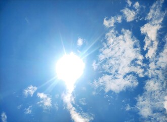 Bright Sun in Blue Sky with White Clouds.