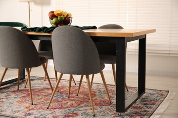 Bowl of fruits on wooden table in dining room. Interior design