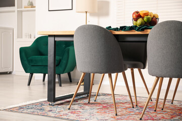 Bowl of fruits on wooden table in dining room. Interior design
