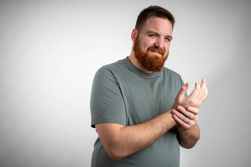 Young man with wrist pain holding painful hand, suffering discomfort from injury or strain on...