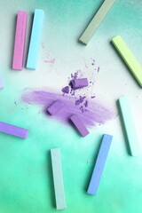 Colorful chalk pastels on color background, flat lay