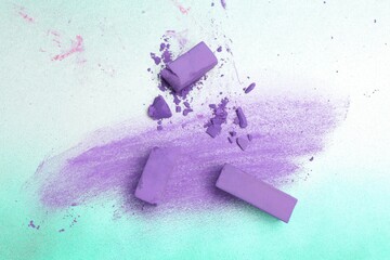 Violet chalk pastels and scribble on color background, flat lay