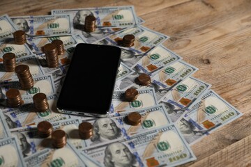 Smartphone and money on wooden table, closeup