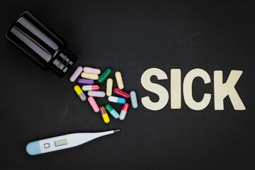 Sick and illness concept. Medicine, pills, and thermometer for treatment on a dark background....
