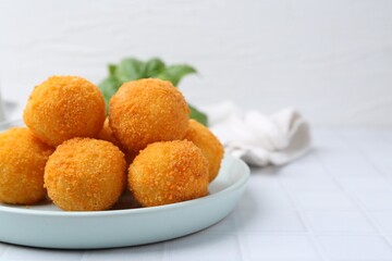 Delicious fried croquette balls on light tiled table, closeup. Space for text
