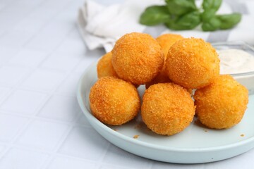 Delicious fried croquette balls on light tiled table, closeup