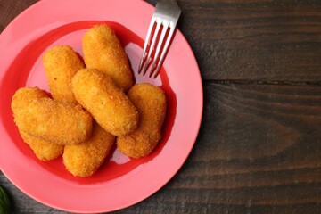 Delicious fried croquettes served on wooden table, flat lay