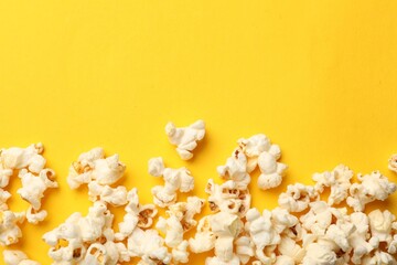 Tasty popcorn on yellow background, flat lay. Space for text
