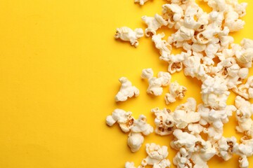 Tasty popcorn on yellow background, flat lay. Space for text