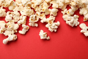 Tasty popcorn on red background, flat lay. Space for text